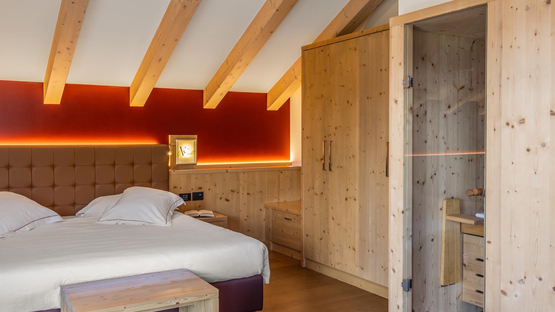 Camera accogliente con letto, armadio e sauna in legno.