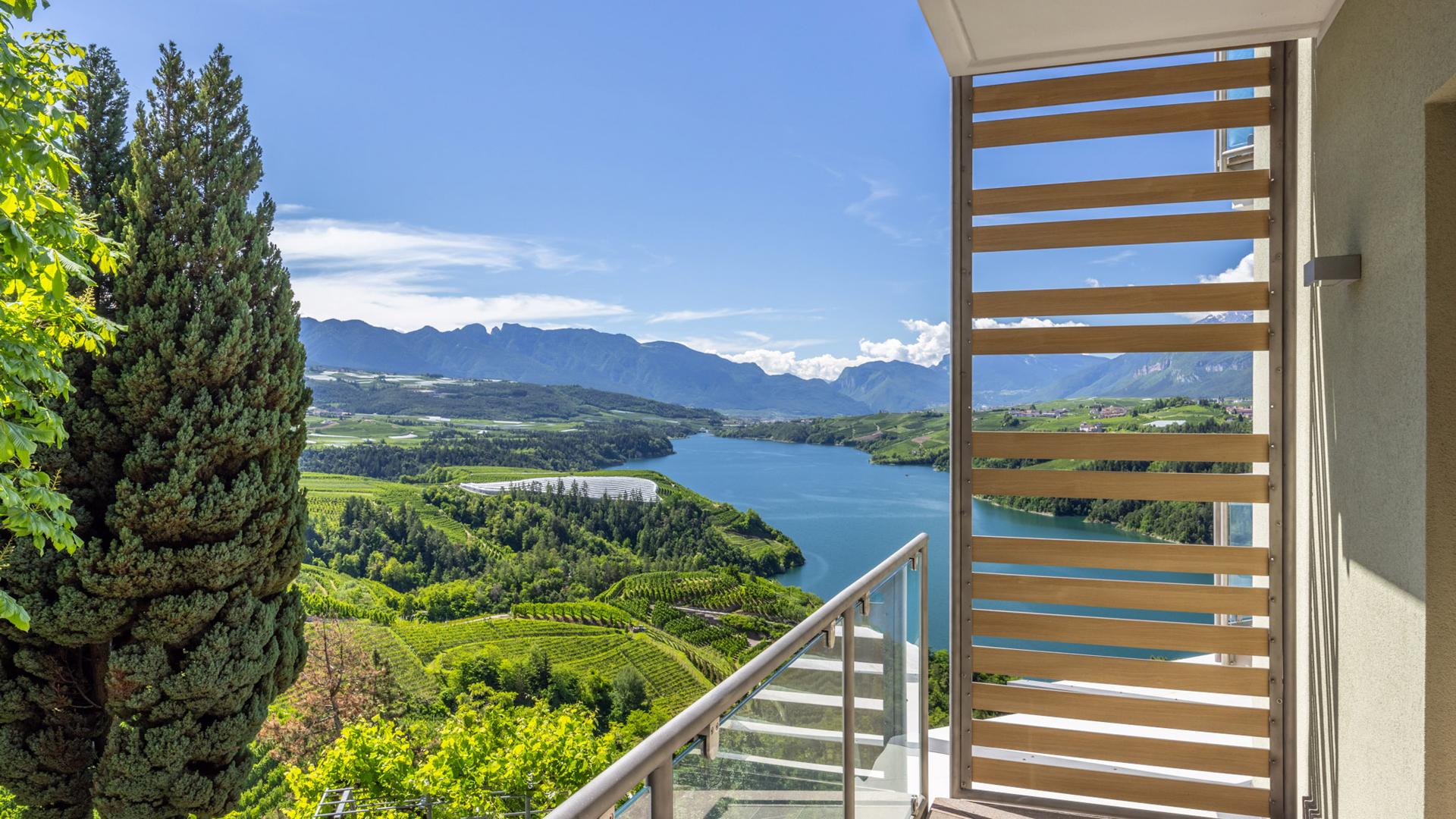 Panoramablick auf See und Berge von einem sonnigen Balkon.